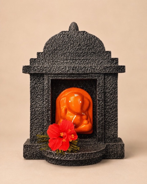Painted terracotta Ganesha in a stone-finish temple with paper flowers